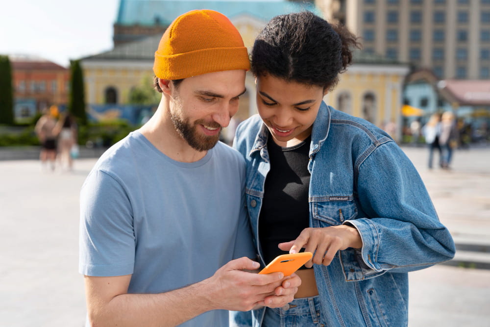 Jeune couple regardant un téléphone.